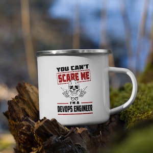 Könnte beinhalten: Weiße Emailtasse mit einem schwarz-weißen Totenkopf- und Knochen-Motiv und dem Text "You can't scare me I'm a DevOps Engineer".