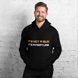 May include: Black hoodie with the text "IT'S NOT A BUG IT'S A FEATURE" in white and orange.