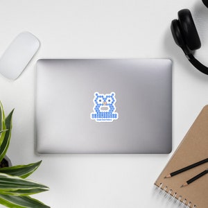 May include: A sticker with a blue owl design composed of small circles. The owl has large eyes and a small beak. The text "Google Cloud Platform" is below the owl in blue. The sticker is on a laptop.