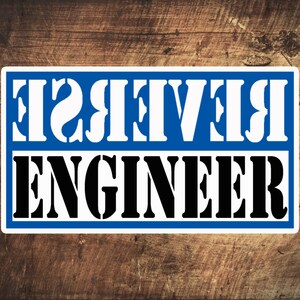 May include: A white sign with blue lettering on a wood background. The sign says "Reverse Engineer" in white letters on a blue background.