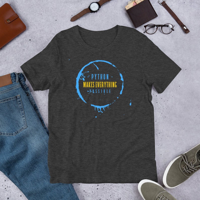 May include: Dark heather grey t-shirt with a blue coffee stain graphic. The graphic has the text "PYTHON MAKES EVERYTHING POSSIBLE" in yellow.