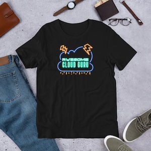 Op de afbeelding: Zwart T-shirt met een neonblauwe en gele afbeelding van een wolk met bliksem en de tekst "Awesome Cloud Guru".