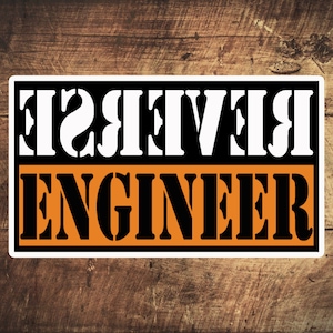 May include: A white sticker with black text that reads "Reverse Engineer" on a brown wooden background.