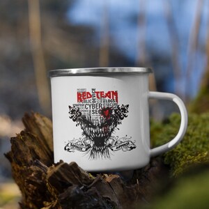 Peut inclure: Une tasse en émail blanche avec un motif graphique rouge et noir. Le graphique représente un crâne avec un cœur rouge et les mots "Red Team" en rouge. Les mots "Défense" et "Attaque" sont de chaque côté du crâne.