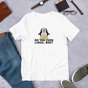Op de afbeelding: Wit T-shirt met een zwart-witte cartoonpinguïn en de tekst "Do you even Linux, bro?"