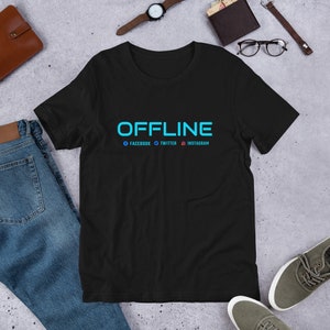 Puede incluir: Camiseta negra con la palabra "OFFLINE" en azul. Debajo de la palabra "OFFLINE" están las palabras "FACEBOOK", "TWITTER" e "INSTAGRAM" con sus respectivos logotipos.