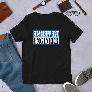 May include: Black t-shirt with a blue rectangle and white text that reads "REVERSE ENGINEER" in reverse.