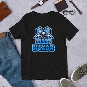 May include: Black t-shirt with a blue and white graphic of a hooded figure with the text "31337 H4XOR".