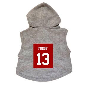 May include: Gray sleeveless hoodie with a red patch on the back that says "FURDY 13" in white.