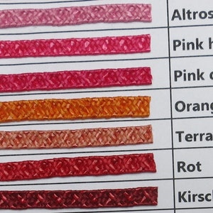 May include: A colour chart with 7 rows of fabric swatches. Each row is numbered from 15 to 21. The fabric swatches are in shades of pink, orange, and red. The names of the colours are listed to the right of the swatches: Altrosa, Pink hell, Pink dunkel, Orange, Terracotta, Rot, Kirschrot.