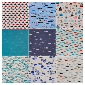Op de afbeelding: Negen verschillende stofstalen met verschillende nautische patronen. De patronen omvatten rode en blauwe walvissen, rode en blauwe vissen, blauwe en witte vlinderdasjes en een selectie van blauwe en witte boten, ankers en vissen.