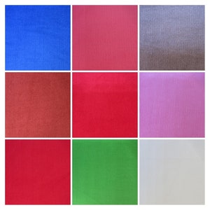 Könnte beinhalten: Eine Sammlung von neun Stoffproben in verschiedenen Farben, darunter Blau, Rot, Rosa, Grün und Weiß. Jede Probe hat eine Cord-Struktur mit vertikalen Rippen.