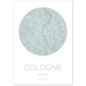 May include: A minimalist print featuring a map of Cologne, Germany, in a circular design. The map is rendered in white lines against a soft, muted green background. The city name, country, and coordinates are printed below.