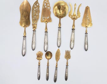 Conjunto de 10 peças de servir em metal dourado no estilo Art Nouveau, incluindo serviço para petit fours, espátulas para tortas e talheres para morangos, finamente gravadas, por volta de 1950/60.