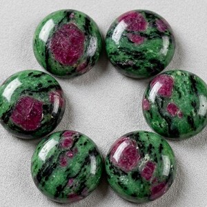 May include: Six polished, circular cabochons made of zoisite with embedded ruby crystals. Each stone features a vibrant green base with black mineral inclusions and distinct, opaque magenta-red ruby patches distributed across the smooth surfaces.