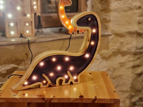 Close-up of the dinosaur lamp showing textured epoxy surface and LED lights