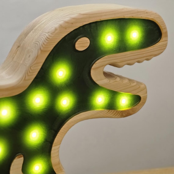 Close-up of a dinosaur night light featuring epoxy resin details and wooden frame