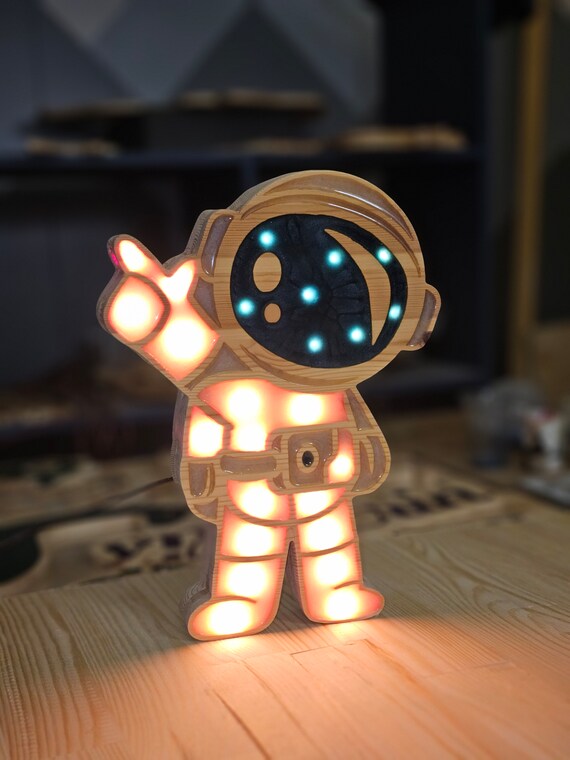 Glowing wooden astronaut decor for a galaxy-themed nursery or playroom