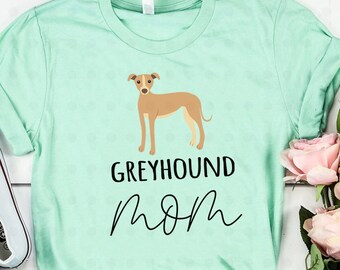 May include: A light green t-shirt featuring a brown and white Greyhound silhouette and the text "Greyhound Mom" in black.