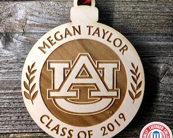 May include: A wooden ornament with the Auburn University logo, the text "Megan Taylor Class of 2019", and a wreath on each side.
