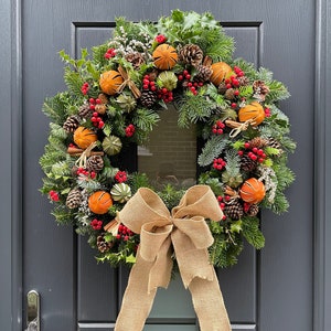 Real Handmade Christmas Wreath with foliage, holly, cones, cinnamon sticks, dried limes and oranges, berries and hessian bow.