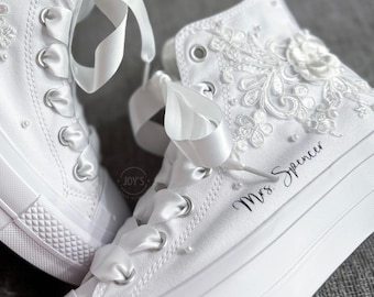 May include: White high-top sneakers with lace detailing and a satin ribbon. The shoes are personalized with the text "Mrs. Spencer".