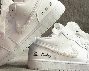 May include: White sneakers with pearl accents on the Nike swoosh and along the side. The text "11.08.25" and "Mrs. Friday" are printed on the shoes. White ribbon laces add a decorative touch.