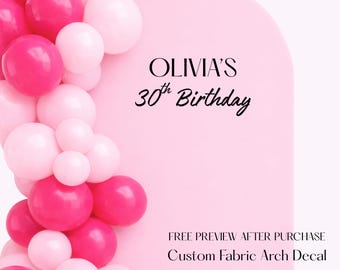 May include: Pink and white balloons cascade down the left side of a pink arch. The text "OLIVIA'S 30th Birthday" is centered on the arch. Below the text is "FREE PREVIEW AFTER PURCHASE Custom Fabric Arch Decal."