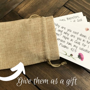 May include: A burlap bag filled with small cards featuring inspirational quotes and scripture verses. The cards have a floral design and are printed with the text "Why are you cast down, O my soul? And why are you in turmoil within me? Hope in God, for I shall praise him, my salvation. Psalms 42:5".