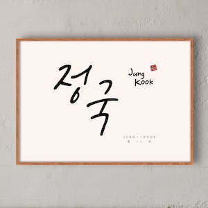 Könnte beinhalten: Ein gerahmter Druck mit dem koreanischen Wort "정국" in schwarzer Kalligraphie. Der Name "Jung Kook" ist unter der Kalligraphie in Englisch geschrieben, mit einem roten Stempel darüber.