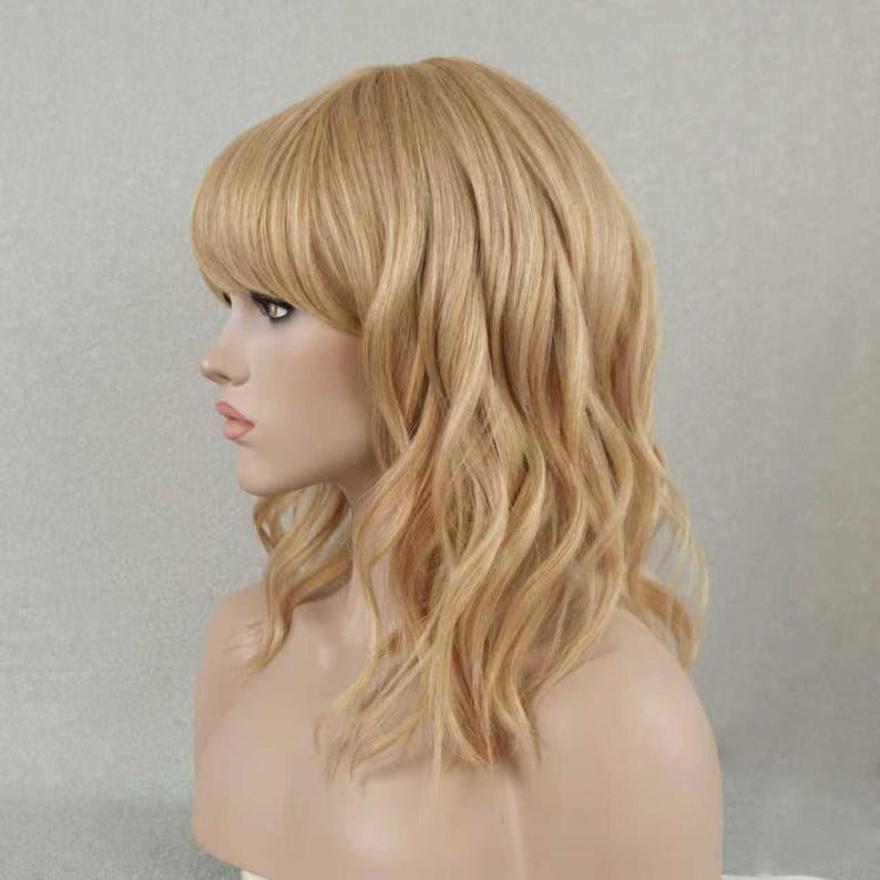 May include: A shoulder-length wig featuring wavy, light blonde hair with a side-swept fringe. The hair has a layered cut with soft, loose waves that frame the face, showcasing a natural-looking texture and a consistent golden blonde color throughout.