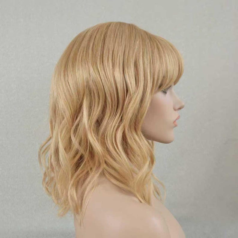 May include: A shoulder-length wig with wavy, light blonde hair and straight-cut bangs. The hair features multi-tonal blonde highlights and lowlights, creating a natural appearance. The wig is styled with a side profile view showing the texture.