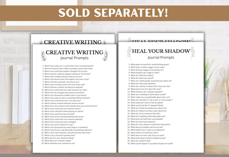 May include: Two journal prompt pages, "Creative Writing" and "Heal Your Shadow", are displayed on a wooden desk. The "Creative Writing" page has 30 prompts. The "Heal Your Shadow" page also has 30 prompts. The text "SOLD SEPARATELY!" is at the top.