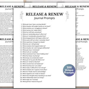 May include: A stack of white paper sheets with the text "RELEASE & RENEW Journal Prompts" in black. The pages list journal prompts for self-reflection, with a blue circle that says "200 Unique Prompts".