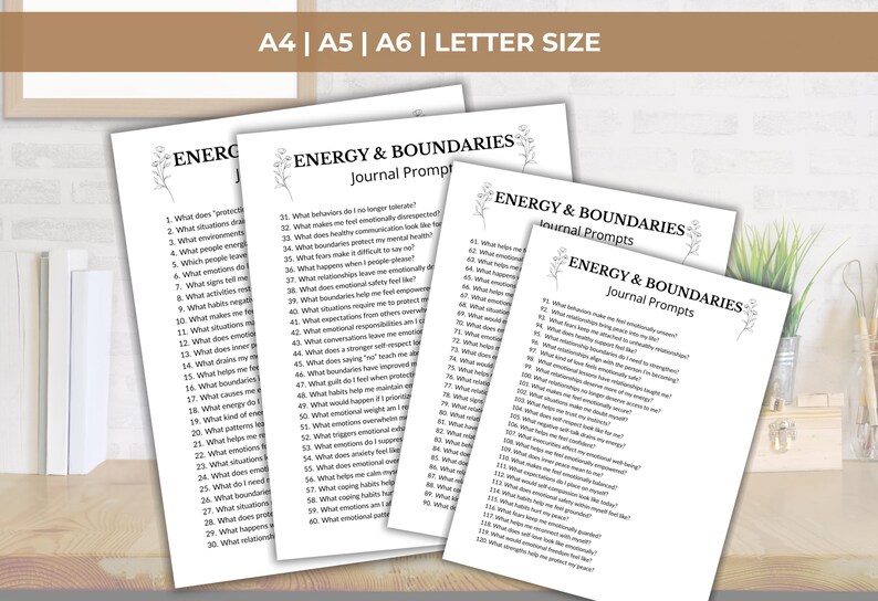 May include: A stack of white paper sheets with the text "ENERGY & BOUNDARIES Journal Prompts" printed in black. The papers are in A4, A5, A6, and Letter sizes. The text includes a list of journal prompts.