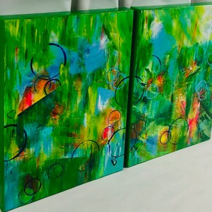 以下が含まれることがあります： 緑色の背景に描かれた抽象画2点。青、黄、赤、オレンジなど、さまざまな色が使われています。絵画は円と線で覆われています。
