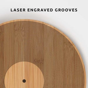 K&ouml;nnte beinhalten: Nahaufnahme einer Holzplatte mit lasergravierten Rillen. Die Platte besteht aus hellbraunem Holz und hat eine dunkelbraune Mitte. Der Text "LASER ENGRAVED GROOVES" steht oben.