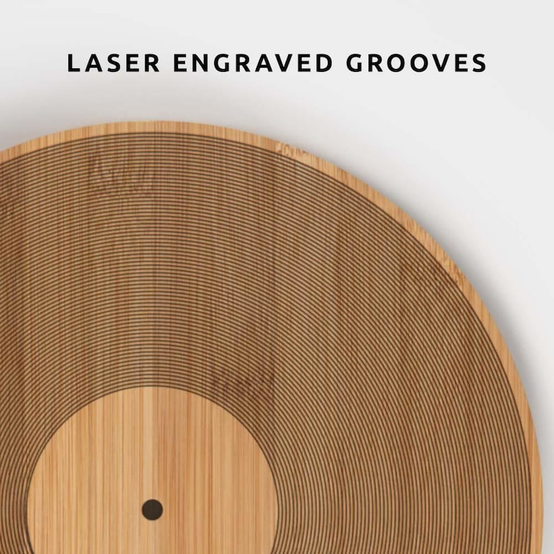 K&ouml;nnte beinhalten: Nahaufnahme einer Holzplatte mit lasergravierten Rillen. Die Platte besteht aus hellbraunem Holz und hat eine dunkelbraune Mitte. Der Text "LASER ENGRAVED GROOVES" steht oben.