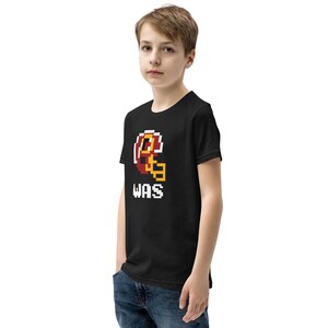 May include: Black youth t-shirt with a pixelated football helmet graphic and the text "WAS" in white.