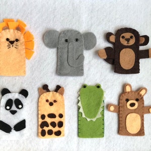 May include: Set of seven felt finger puppets featuring various animals, including a lion, elephant, monkey, panda, giraffe, crocodile, and bear. The puppets are all brightly colored and have friendly faces.