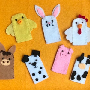 May include: Set of 8 felt finger puppets featuring farm animals, including a chicken, cow, pig, horse, dog, rabbit, and chick. The puppets are made of felt and have embroidered details.
