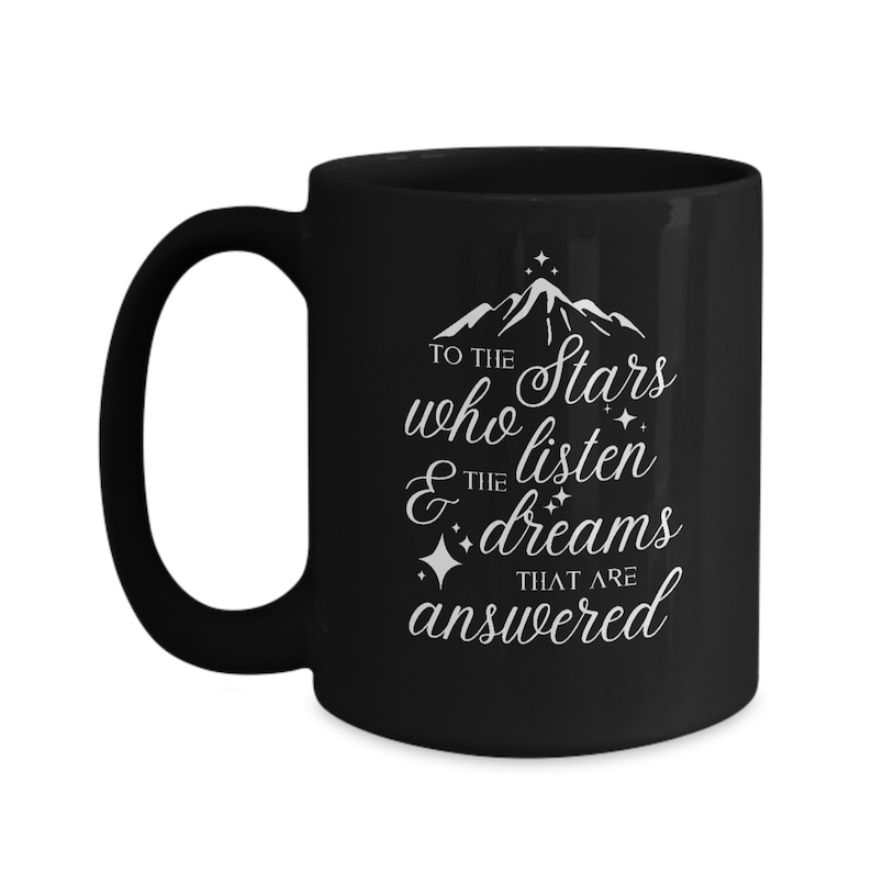 May include: Black ceramic coffee mug with a white design that reads "To the stars who listen & the dreams that are answered".