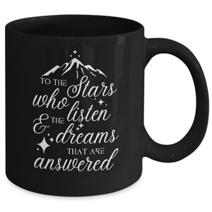 May include: Black coffee mug with white text that reads "To the stars who listen & the dreams that are answered". The text is surrounded by small stars.