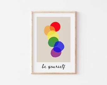 May include: A framed print with a beige background and a rainbow of overlapping circles. The text "be yourself" is printed below the circles.