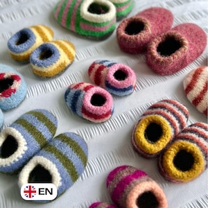 Könnte beinhalten: Eine Auswahl handgefertigter Wollpantoffeln in verschiedenen Farben und Streifenmustern. Die Pantoffeln haben eine runde Spitze und eine kontrastierende Innenseite. Farben sind u.a. Pink, Grün, Blau, Gelb und Rot. Präsentiert auf einer weißen, strukturierten Oberfläche.