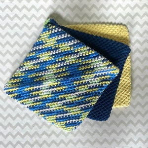 May include: Three crocheted pot holders in blue, yellow, and white. The pot holders are stacked on top of each other.