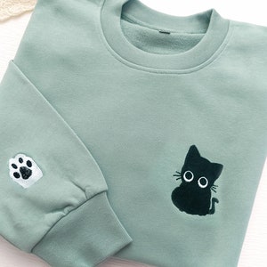 かわいい黒猫の刺繍入りスウェットシャツ、刺繍入り黒猫のスウェットシャツ、クルーネックスウェットシャツ、ユニセックススウェットシャツ、猫好きの方へのギフト