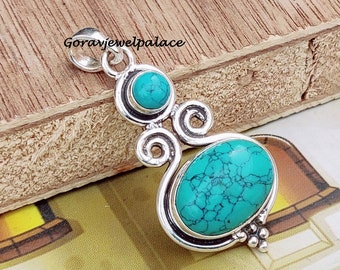 May include: Silver pendant with two turquoise stones. The larger stone is oval shaped and the smaller stone is round. The pendant has a swirl design.