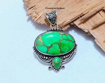 May include: A silver pendant with a large oval green turquoise stone and a smaller teardrop-shaped turquoise stone. The pendant has intricate silver detailing.