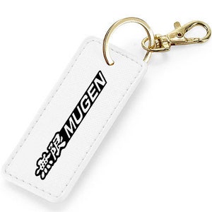 Peut inclure: Porte-clés en cuir blanc avec un anneau en métal doré et un logo noir qui dit "無限 MUGEN".